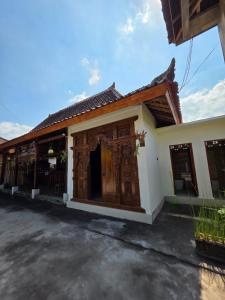 a building with a large wooden door at Aura V Bungalow in Praya