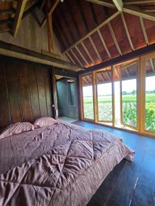 a large bed in a room with windows at Aura V Bungalow in Praya