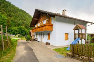 a house with a wooden balcony and a playground at Altebnerhof Leifers in Laives