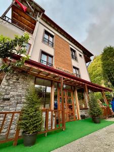 a building with a green lawn in front of it at YAYLAMİSUN SUITE HOTEL Luxury Nature Stay Çamlıhemşin in Çamlıhemşin