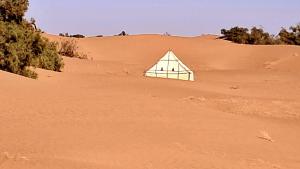 a pyramid tent in the sand in the desert at Caravane du bonheur in Mhamid
