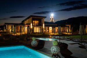 a house with a swimming pool at night at Maria village resort in Pavel Banya