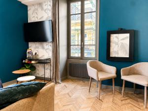 a living room with blue walls and a couch and chairs at La Loge AL'AIX in Aix-les-Bains