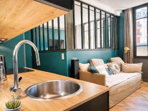 a kitchen with a sink and a couch at La Loge AL'AIX in Aix-les-Bains +8 photos