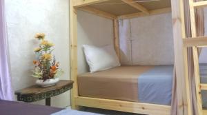 a bunk bed with a vase of flowers on a table at Rooftop Hostel Dakhla in Dakhla