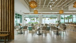 a dining room with tables and chairs and windows at South Seas in Captiva