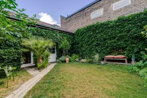a garden in front of a brick building at Cocon au fond du jardin in Souffelweyersheim