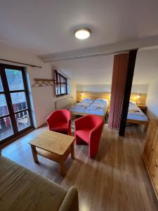 a room with two beds and a table and chairs at Penzion Stárek in Terchová