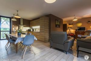 a kitchen and living room with a table and chairs at Le Moulin de Commagny in Moulins-Engilbert