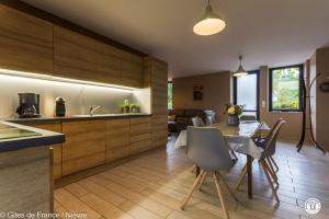 a kitchen and dining room with a table and chairs at Le Moulin de Commagny in Moulins-Engilbert