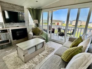 a living room with a couch and a table at Craig Tara Holiday Park 101 Bay View in Ayr
