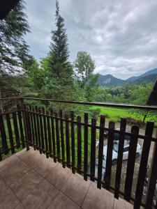 a fence with a view of a river and mountains at Willa Zwinka in Szczawnica