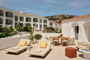 a patio with a table and chairs and a building at W Sardinia - Poltu Quatu in Porto Cervo