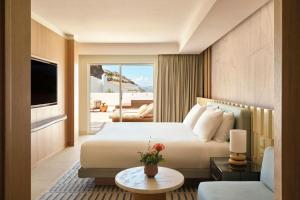 a hotel room with a bed and a living room at W Sardinia - Poltu Quatu in Porto Cervo