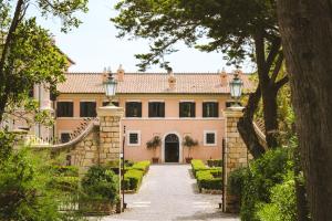 an exterior view of a house with a driveway at La Posta Vecchia Hotel in Ladispoli