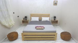 a bedroom with a bed with two ottomans and twounks at Rooftop Hostel Dakhla in Dakhla