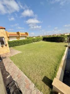 a yard with a large lawn withgrass at شاليه بقرية الفيروز in Qaryat Shurūq