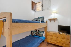 a bedroom with two bunk beds and a tv at Casa Silvia trilo calagavetta in La Maddalena