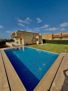 a large blue swimming pool in front of a house at شاليه بقرية الفيروز in Qaryat Shurūq +10 photos