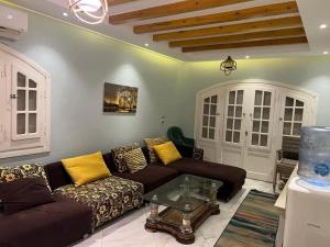 a living room with a couch and a table at شاليه بقرية الفيروز in Qaryat Shurūq