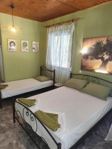 two beds in a room with a window at Asmanis Rooms in Tarti