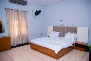 a bedroom with a large bed with white sheets at NBTE Hotels in Kaduna