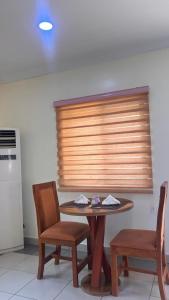 a kitchen with a table and two chairs and a window at NBTE Hotels in Kaduna