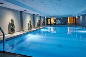 a swimming pool with blue water in a building at Grand Jersey Hotel and Spa in Saint Helier Jersey