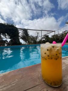 a drink sitting on a table next to a swimming pool at Pensão Asa Branca in Assomada