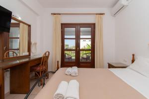 a bedroom with a desk and a bed and a mirror at Star Paradise Hotel in Neos Marmaras +62 photos