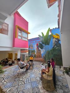 a group of people sitting in chairs in front of a mural at Casa Carmesí Zapatoca in Zapatoca