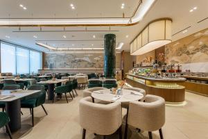 a restaurant with tables and chairs and a bar at Radisson Blu Hotel, Tashkent in Tashkent