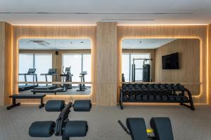 a gym with a large mirror and rows of equipment at Radisson Blu Hotel, Tashkent in Tashkent