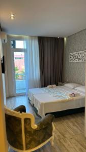 a bedroom with two beds and a chair in it at National Lux in Ureki