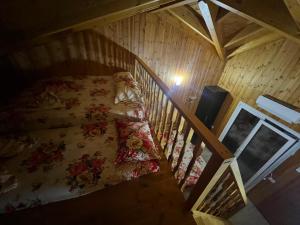 ein Bett in einem Holzzimmer mit Treppe in der Unterkunft Kalaj in Tale