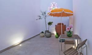 a room with a table and an umbrella and plants at Vie Del Salento in San Pancrazio Salentino