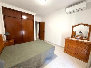 a bedroom with a bed and a dresser and a mirror at Edificio Nau in Armação de Pêra +10 photos