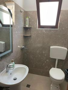 a bathroom with a sink and a toilet and a window at Besart Room in Orikum