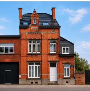a red brick building with a gambrel roof at The Manhattan Luxury suite in Jumet