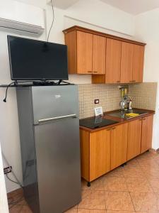 a kitchen with a stainless steel refrigerator and wooden cabinets at Besart Room in Orikum