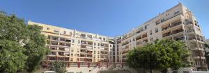 a large apartment building with trees in front of it at Edificio Nau in Armação de Pêra