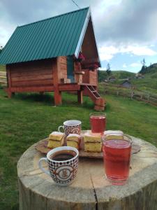 a table with cups of coffee and cakes on a stump at Eko Kamp Garcevic in Plav