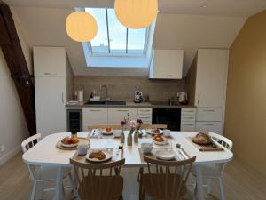 a kitchen with a white table with food on it at Le Refuge des Clavendiers in Nuits-Saint-Georges