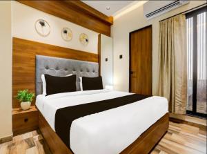 a bedroom with a large white bed and a window at Hotel the Infinity in Rajkot +3 photos