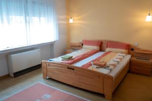 a bedroom with a large wooden bed with a window at Ferienwohnung Weißburgunder in Klüsserath