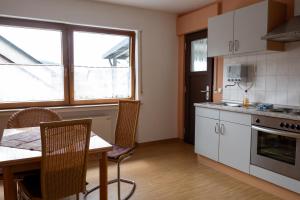 a kitchen with a table and a dining room at Ferienwohnung Weißburgunder in Klüsserath