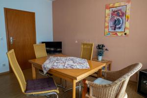 a dining room with a wooden table and chairs at Ferienwohnung Weißburgunder in Klüsserath +8 photos