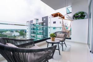 a balcony with chairs and a table and a window at Modern 3BR! 9fl, King Bed! Sti!, in Santiago de los Caballeros