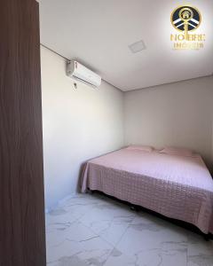 a small bedroom with a bed and a air conditioner at Casa completa com 2 quartos no Bairro Alvorada in Santarém