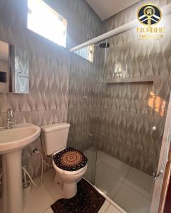 a bathroom with a toilet and a sink and a shower at Casa completa com 2 quartos no Bairro Alvorada in Santarém